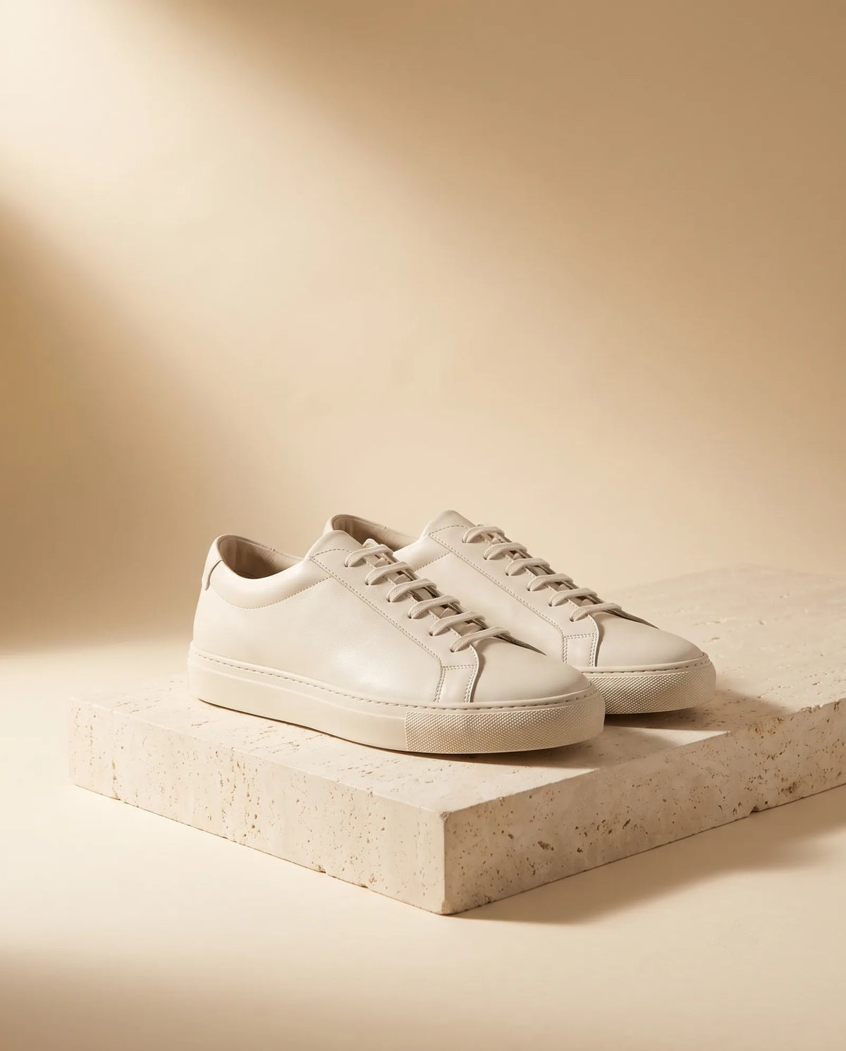 Off-white leather sneakers on stone plinth